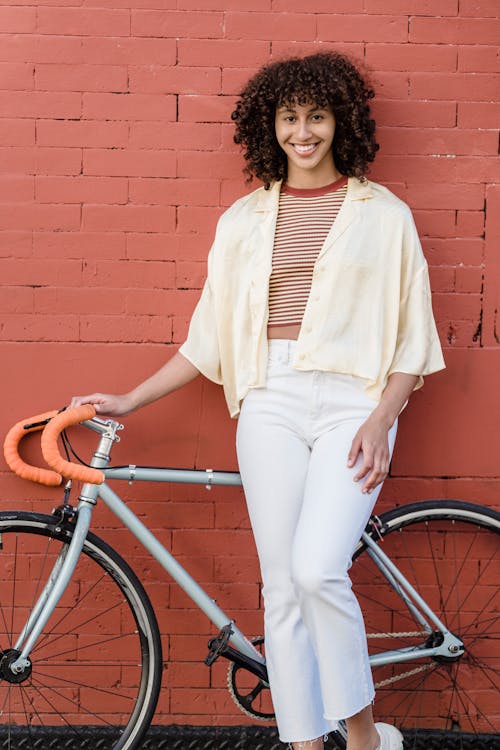 Curly-Haired Woman Standing Beside a Bicycle