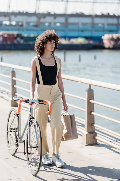 Woman with Bike Walking on Bridge