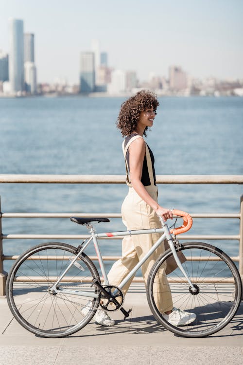 A Woman Walking with a Bike in a City