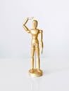 A Golden Wooden Figure on a White Surface