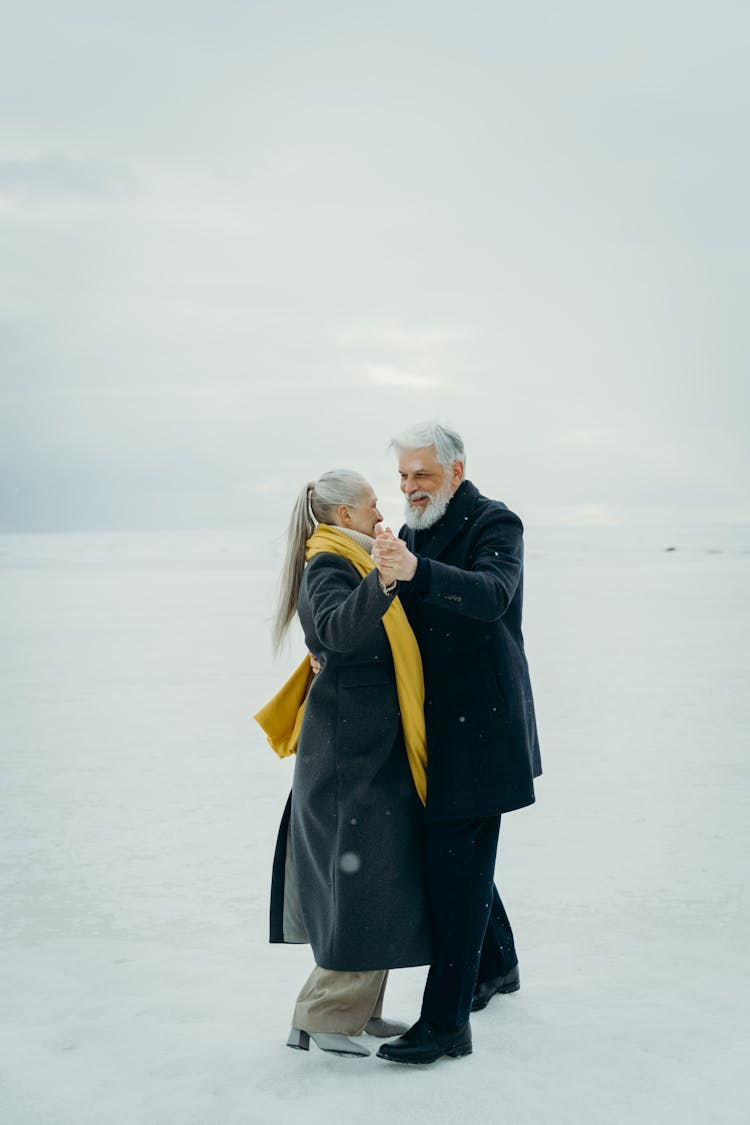 Elderly Couple Dancing On Snow Covered Ground