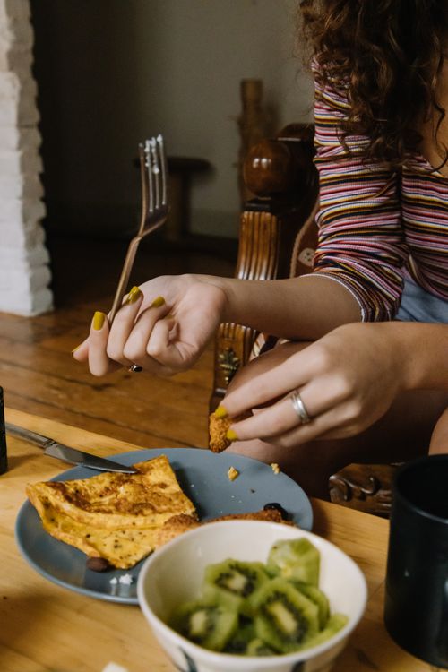 Free Cozy breakfast scene with pancakes and kiwi, captured indoors in a relaxed setting. Stock Photo