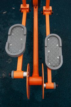 Close-up view of fitness equipment on rubber mat outdoors, highlighting texture and color.