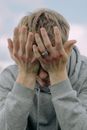 A Man with Bruised Knuckles Having a Headache