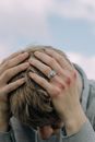 A Man with Bruised Knuckles Having a Headache
