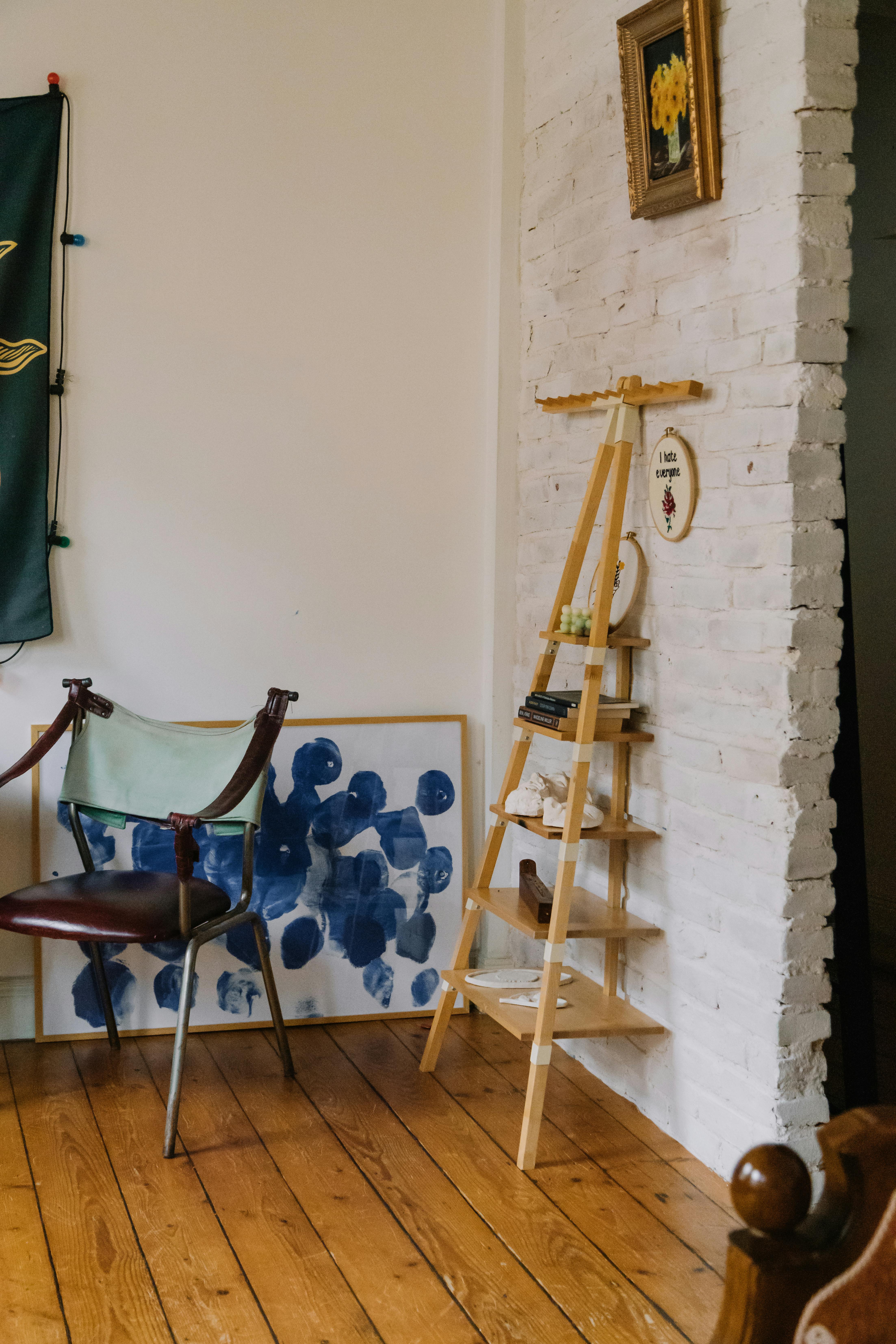 Free A cozy room corner featuring art, a chair, and unique shelving displaying decor. Stock Photo