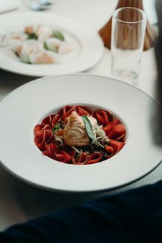 A beautifully presented elegant dish featuring salmon and decorative vegetable ribbons, perfect for gourmet dining.