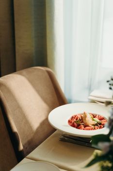 A gourmet dish elegantly presented on a restaurant table, illuminated by soft natural light.