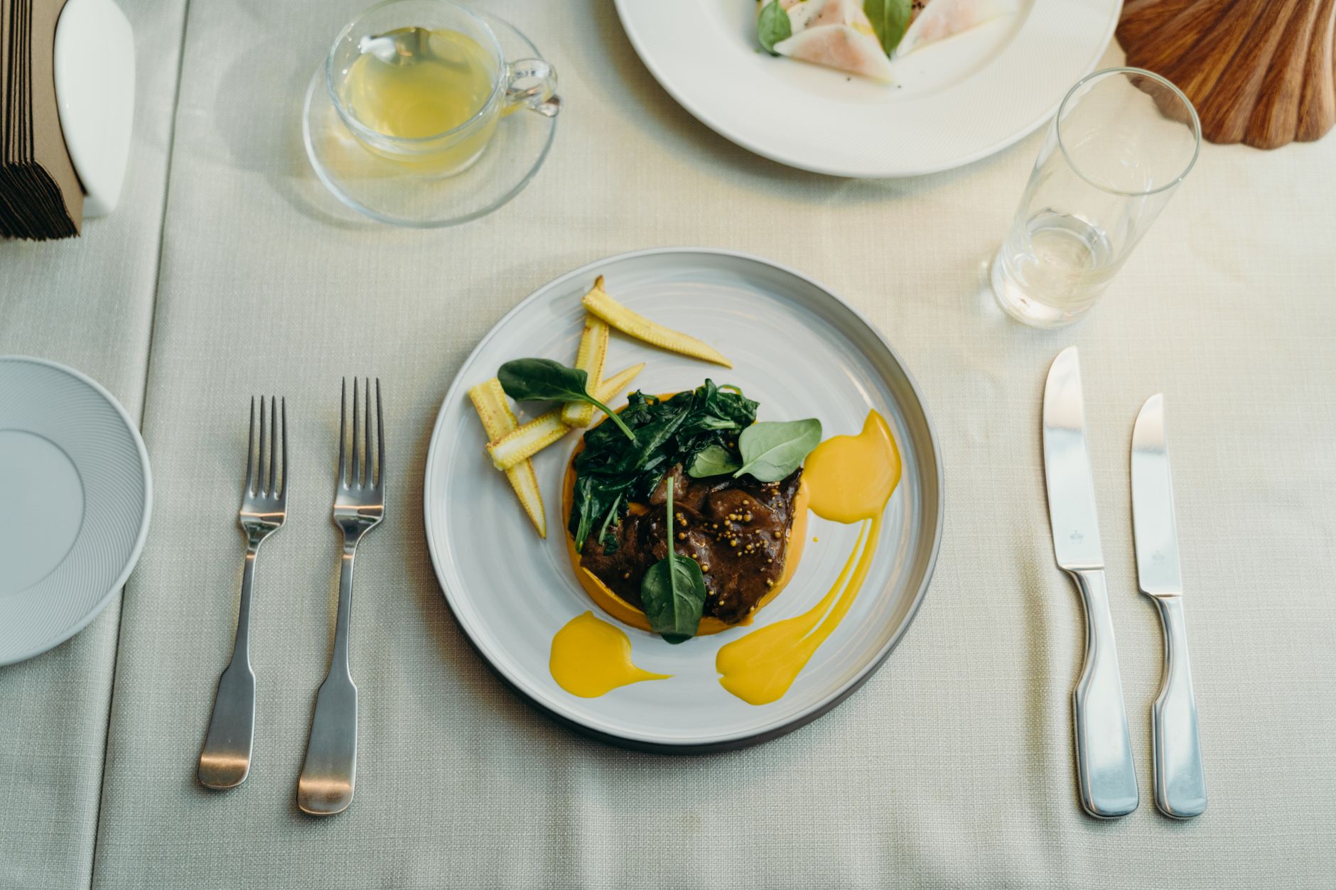Delicious gourmet beef dish served with vegetables and sauce, styled on an elegant dining table.