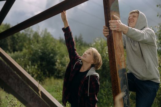 Two teenagers climbing a structure in a scenic outdoor setting, embodying adventure and street style.