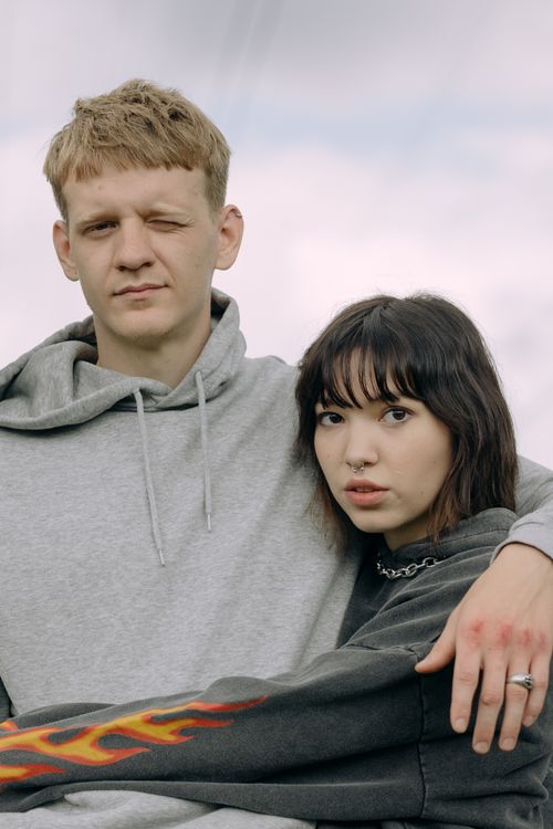 Free A young couple in casual attire embracing outdoors, conveying a warm and intimate connection. Stock Photo