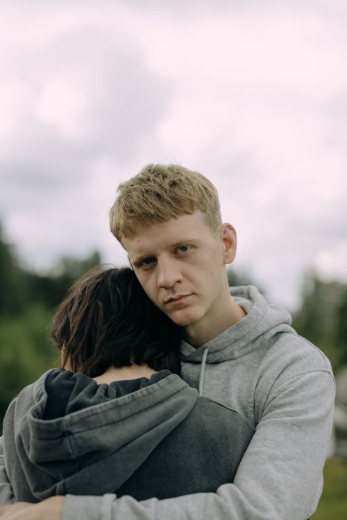 Free A young couple shares a heartfelt hug outdoors, expressing love and support. Stock Photo