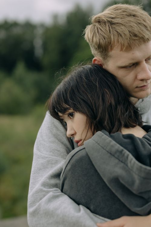 Free Close-up of a young couple embracing peacefully in a natural outdoor setting, conveying warmth and connection. Stock Photo
