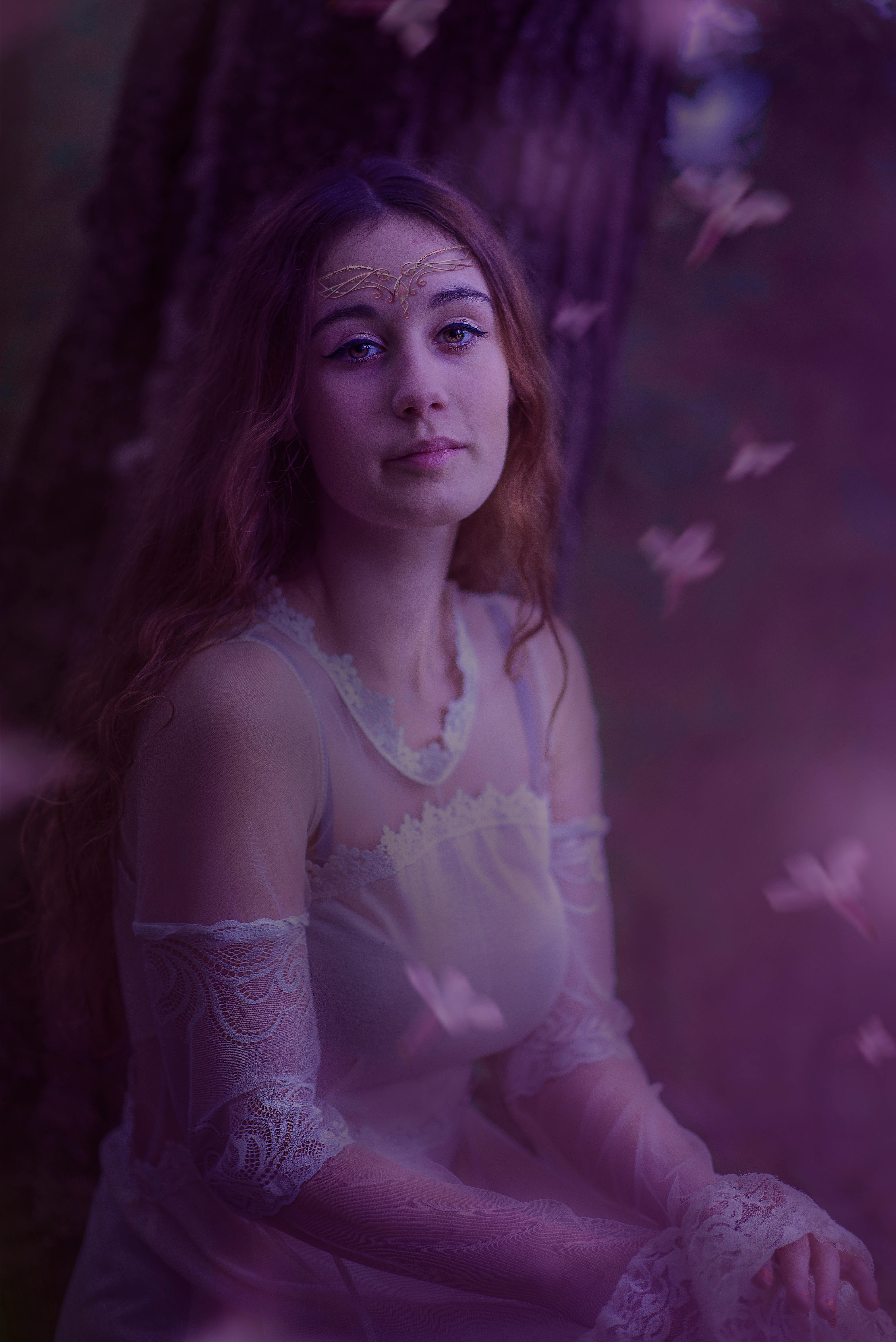 A mystical portrait of a woman in a fantasy costume enveloped in a dreamy, magical atmosphere.