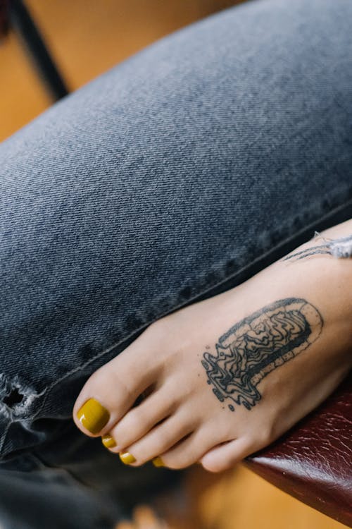 Close-Up Photo of a Person's Foot with a Tattoo