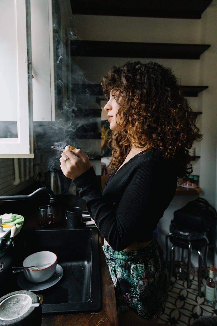 Woman Smoking In The Kitchen