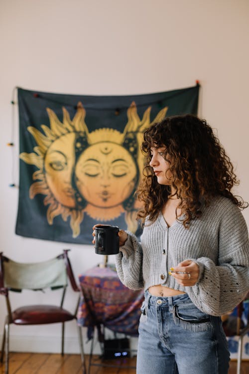 Woman in a Gray Sweater Holding a Black Mug