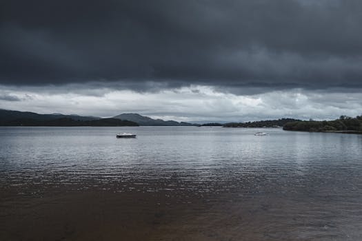 A picturesque view of a lake with dramatic clouds and boats, captured in England.