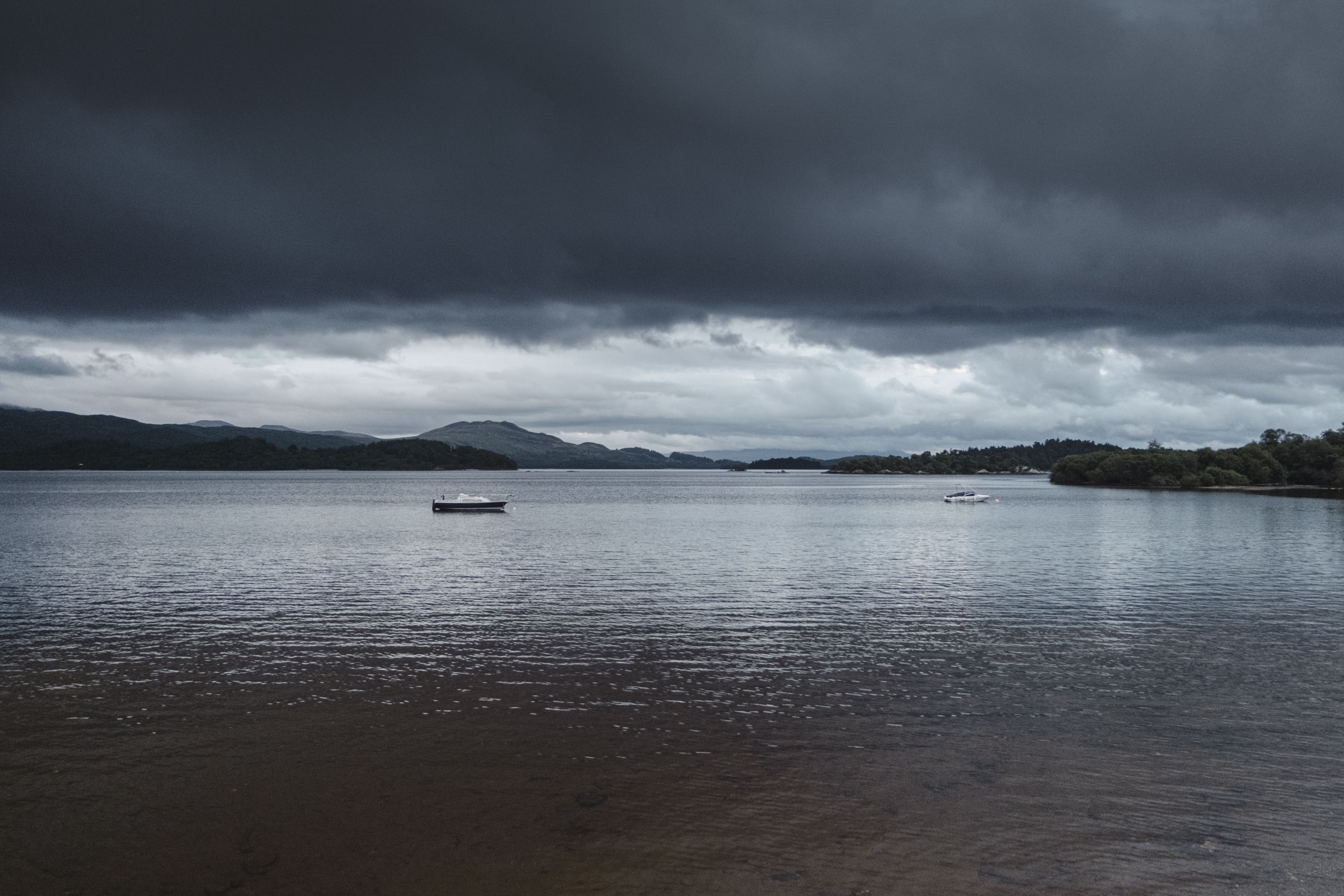 Boats on rippling river during storm · Free Stock Photo