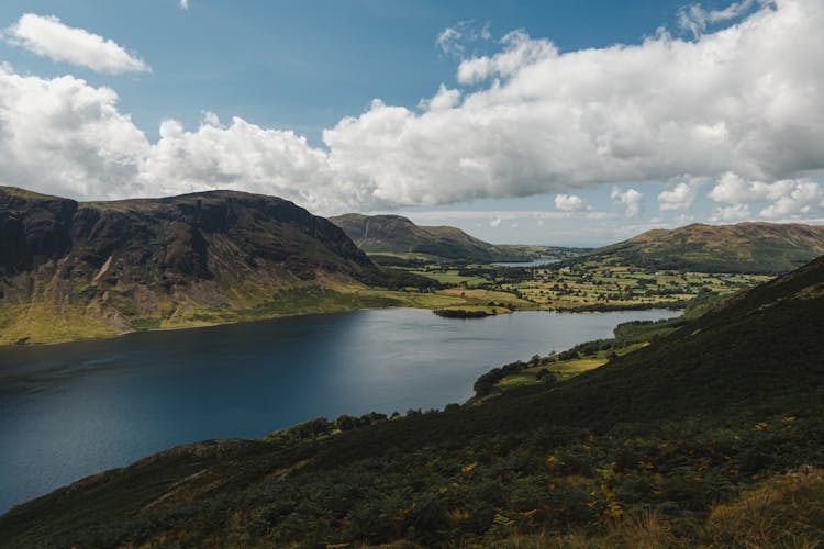 River Amidst Hills On Cloudy Day