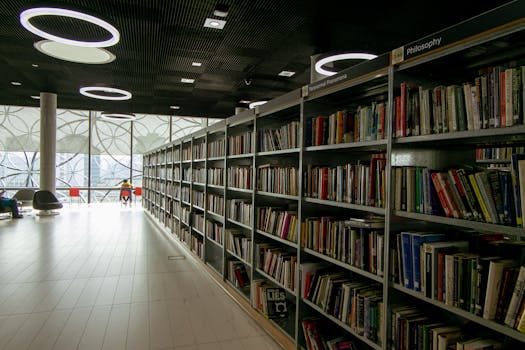 A quiet modern library interior with bookshelves and bright circular lights.