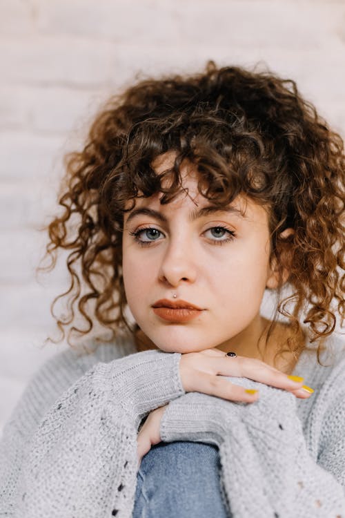 Free Close-Up Shot of a Curly-Haired Woman Looking at Camera Stock Photo