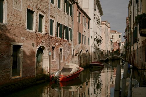 Free Charming view of Venice's narrow canal with historic buildings and boats. Stock Photo