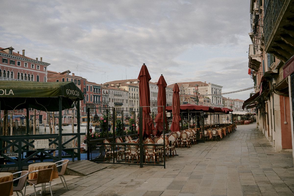Mese pe trotuar langa un canal, intr-o dimineata linistita