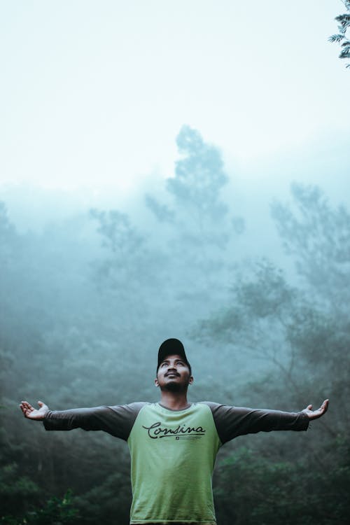 Man Wearing Black and Green Long Sleeve Shirt and Cap