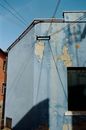 Exterior of old blue apartment building with cracked paints located in town district on sunny day