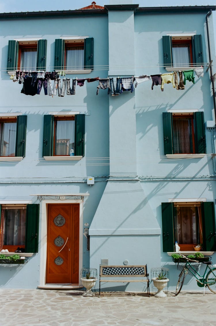 Blue Residential Building Near Drying Laundry On Clothesline