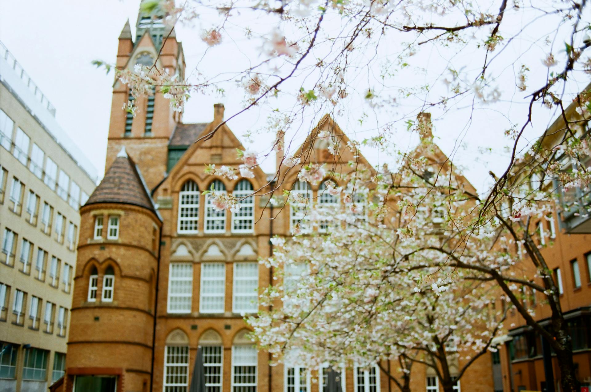 Exterior of historic building with clock on spire in Birmingham on clear spring day