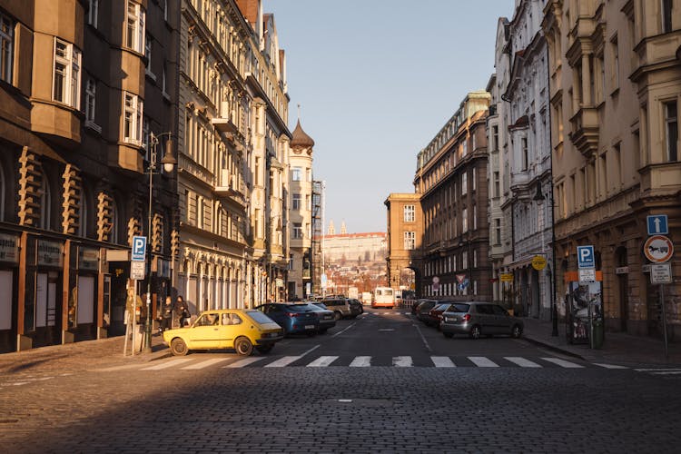 Cars On Road Between Old Urban Building Facades