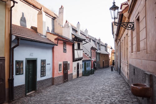 Free Cobblestone street between old residential house exteriors in town Stock Photo