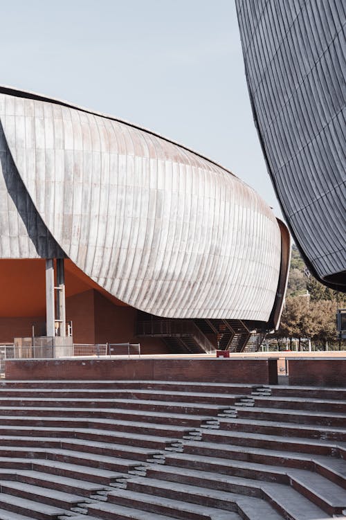 Creative design of contemporary music complex facades and staircase under light sky in sunlight in Rome Italy