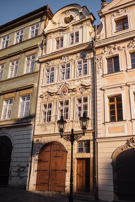 Low angle of old stone building exterior with arched doors and ornament on walls in Prague Czech Republic