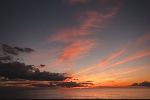 Cloudy sky over rippled ocean at night