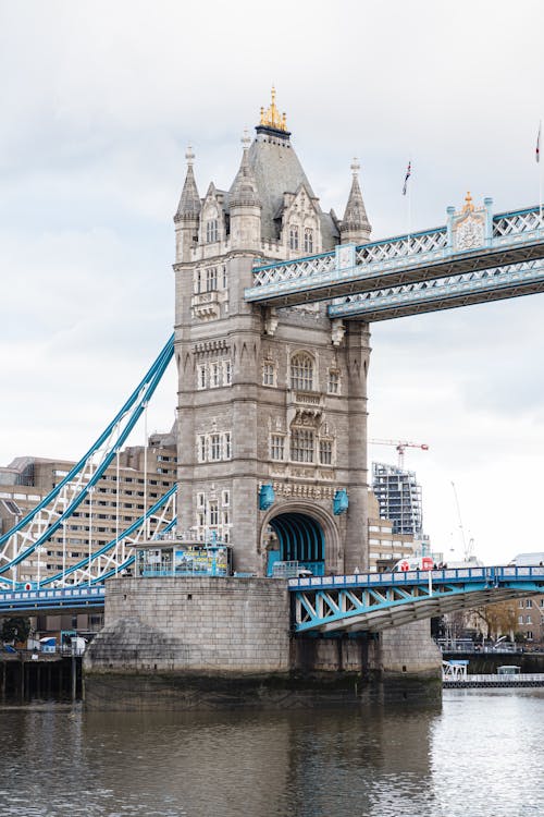 Free Detail of famous stone Tower Bridge with walkways over calm river near residential houses located on street of London city Stock Photo