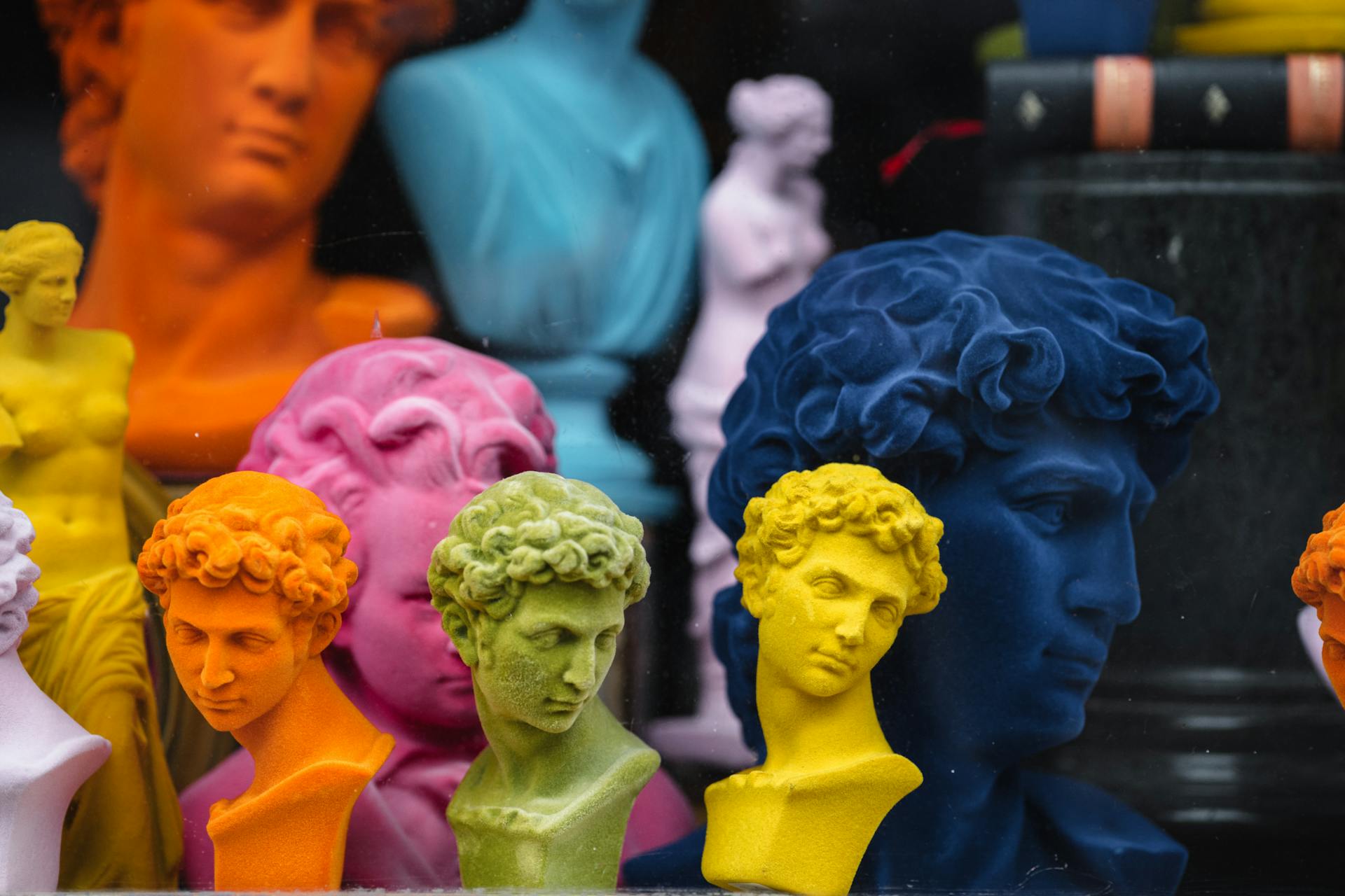 Collection of colorful head sculptures of David in different colors and shapes placed on counter in store with decorative souvenirs