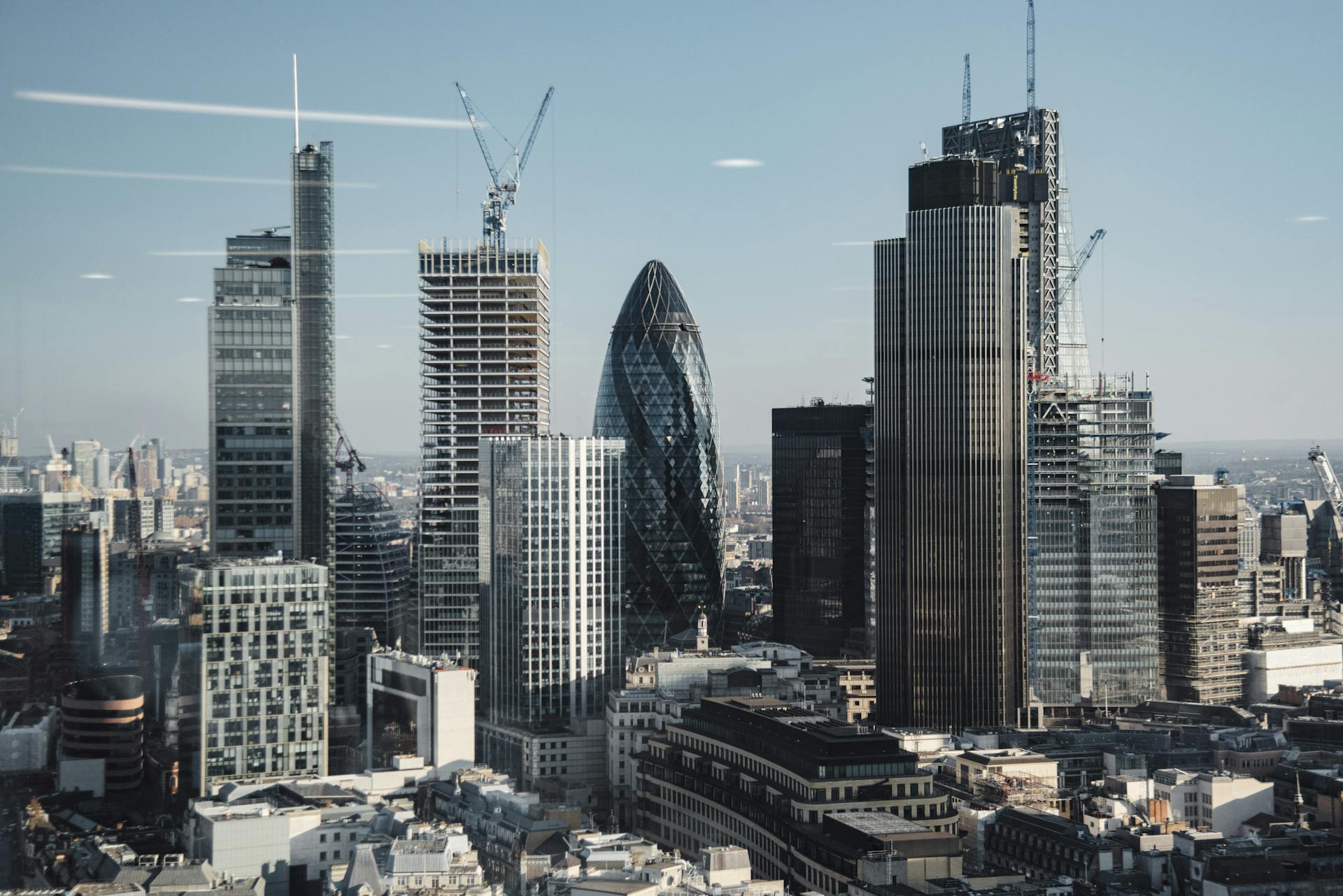 Various shaped modern skyscrapers with glass mirrored facades located in financial district of London against blue sky on sunny day