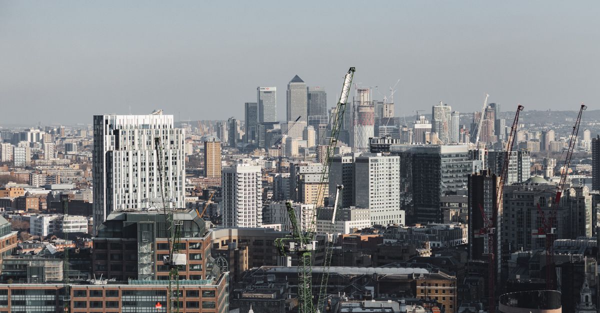 Scenic cityscape of London district with contemporary multistory buildings and crane towers under cloudy sky in daylight