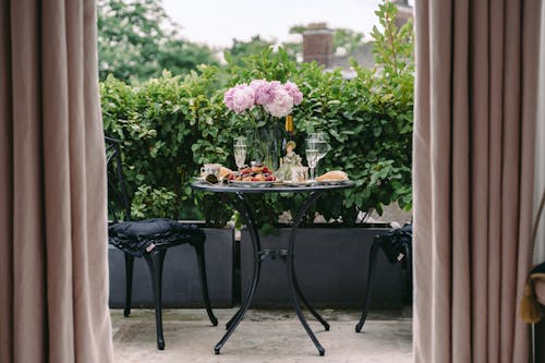 Free Breakfast table with elegant flowers and wineglasses on veranda of classic styled villa Stock Photo