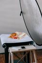 Many different little mushrooms placed on table near smartphone with black screen in photo studio