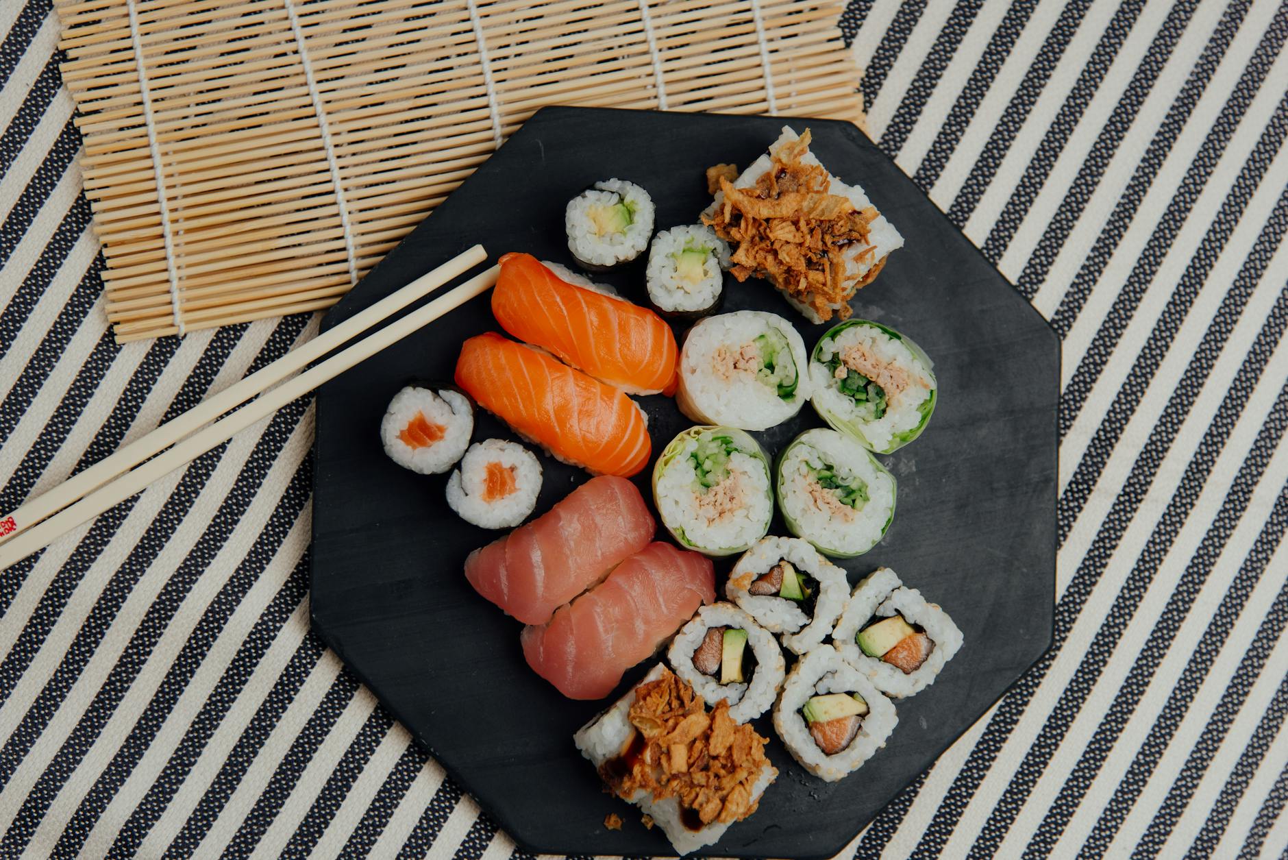 Plate with sushi rolls near chopsticks