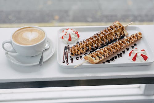 Free Tasty waffles covered with chocolate topping and cup of coffee Stock Photo