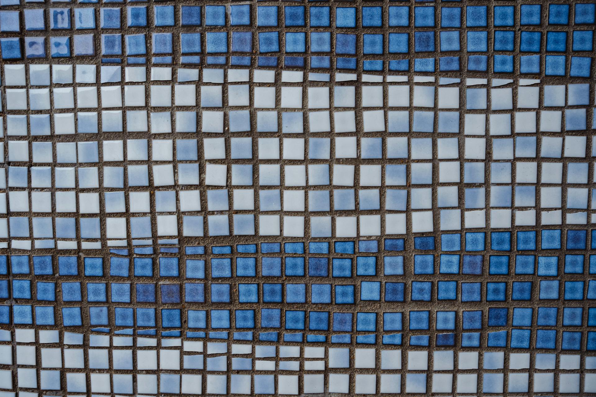 Textured ceramic square shaped white and blue tile of wall of old building