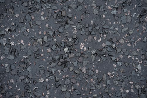 Top view of rough gray asphalt wet pavement of urban street on rainy day