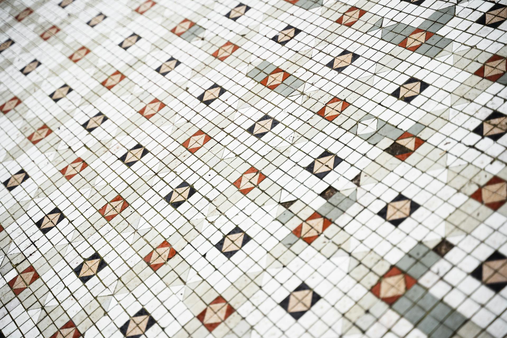 From above of geometric pattern of symmetrical ceramic tile on wall in daylight