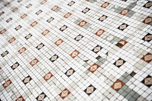 From above of geometric pattern of symmetrical ceramic tile on wall in daylight