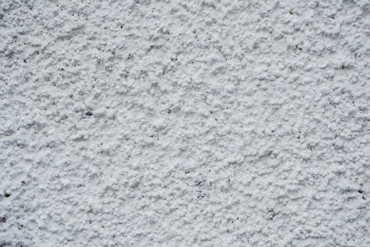Close-up view of a textured white concrete wall with rough surface pattern.